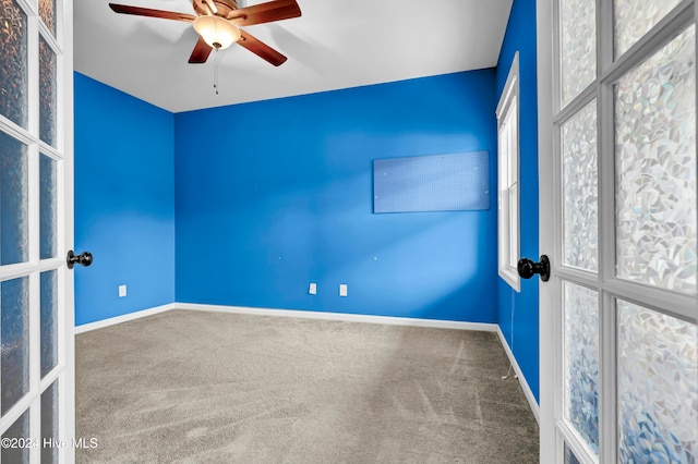 carpeted spare room featuring ceiling fan