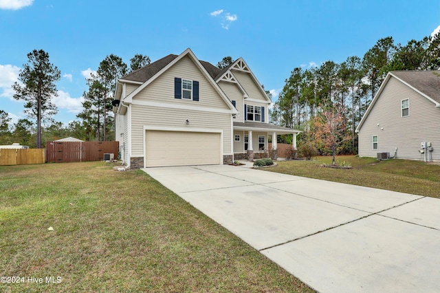 view of front of home featuring a porch, central AC unit, a front yard, and a garage