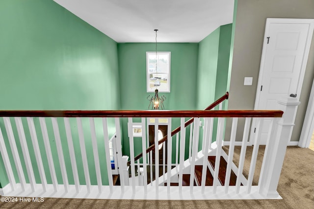 stairs featuring carpet floors and an inviting chandelier