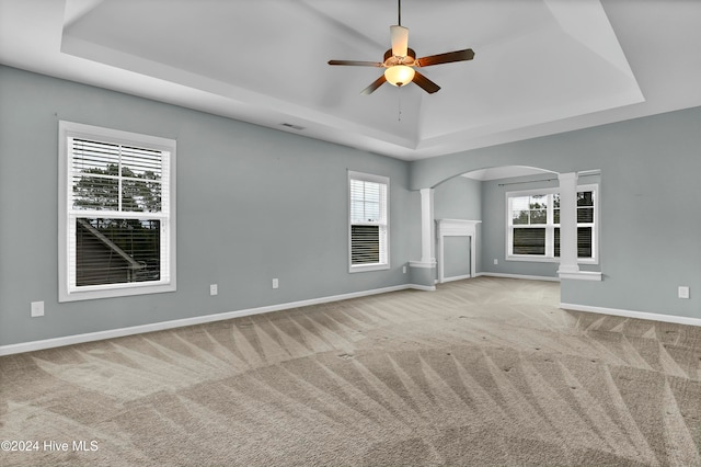 unfurnished living room with light colored carpet, a raised ceiling, and ceiling fan