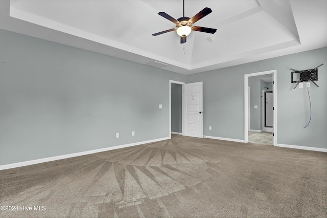 interior space featuring a tray ceiling, light carpet, and ceiling fan