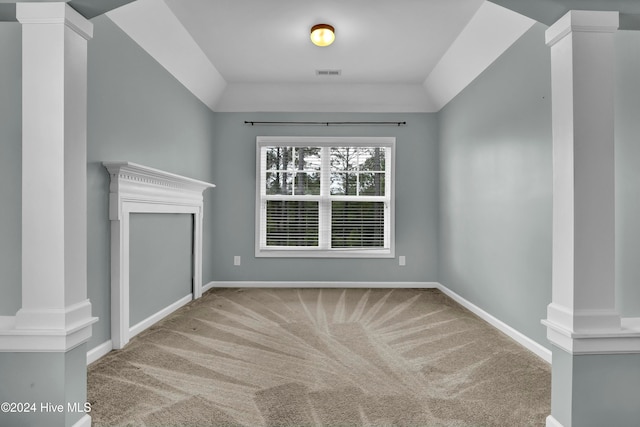 unfurnished living room featuring light carpet and decorative columns