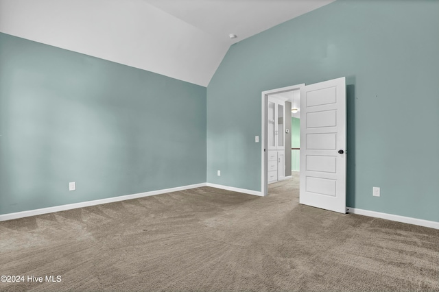 empty room with carpet flooring and lofted ceiling