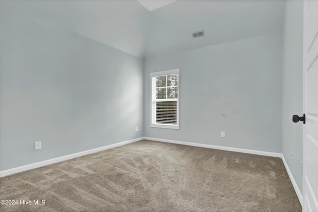 unfurnished room featuring carpet flooring and lofted ceiling