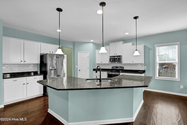 kitchen featuring a center island with sink, pendant lighting, white cabinetry, and stainless steel appliances