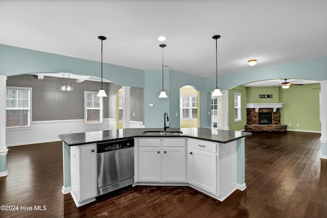 kitchen featuring white cabinetry, sink, hanging light fixtures, stainless steel dishwasher, and dark hardwood / wood-style floors