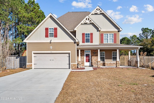 craftsman house featuring a porch, a front yard, and a garage