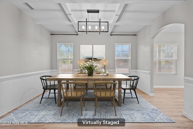 dining space featuring a wealth of natural light, beamed ceiling, and light hardwood / wood-style floors