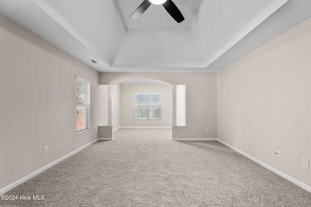 carpeted spare room featuring ceiling fan and a tray ceiling