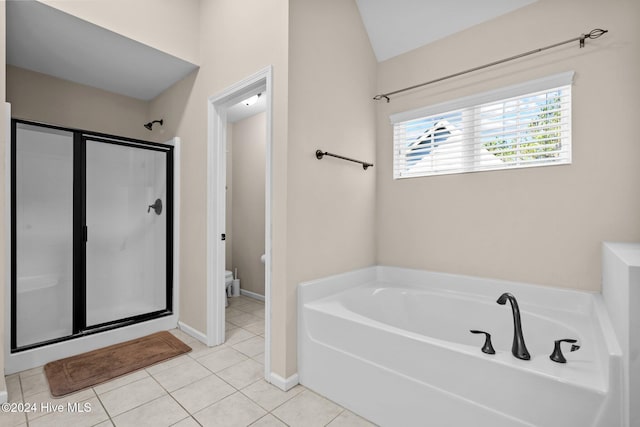 bathroom with tile patterned floors, independent shower and bath, lofted ceiling, and toilet