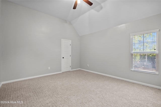 carpeted empty room featuring ceiling fan and vaulted ceiling