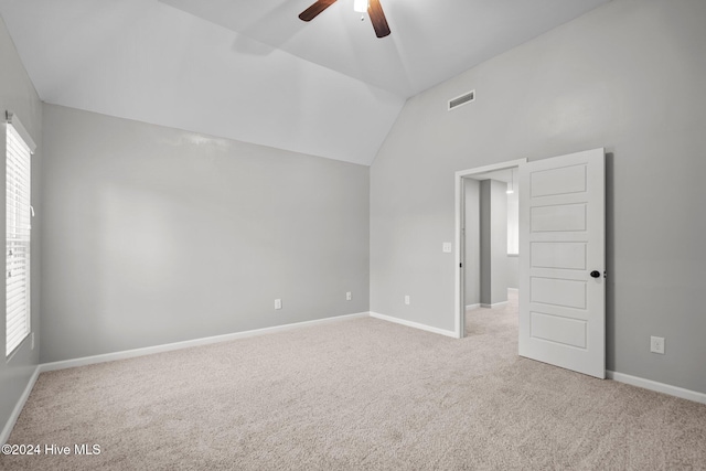 unfurnished room featuring light colored carpet, vaulted ceiling, and ceiling fan