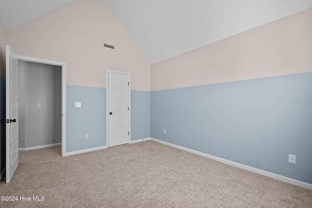 unfurnished bedroom with carpet flooring, a closet, and high vaulted ceiling