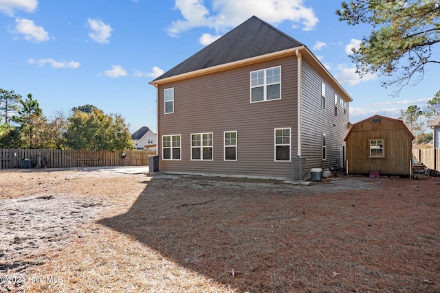 rear view of property with central AC and a shed