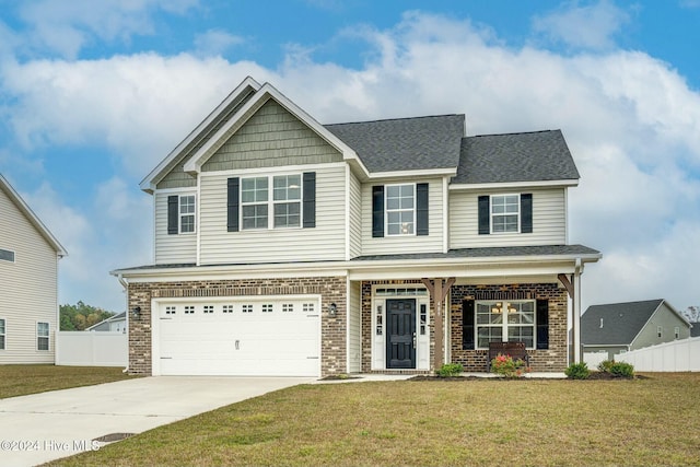 craftsman house with driveway, brick siding, a front lawn, and fence