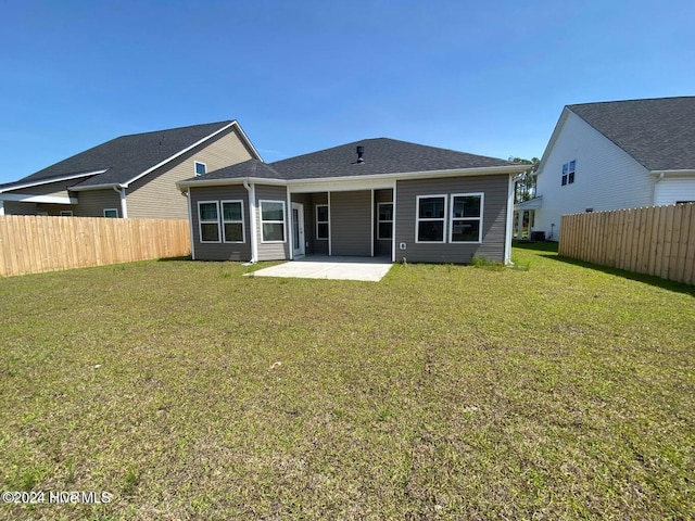 rear view of house featuring a yard and a patio