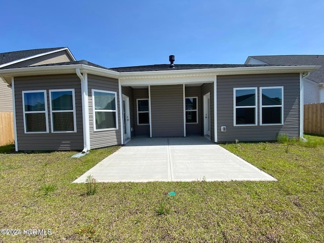 back of property with a lawn and a patio