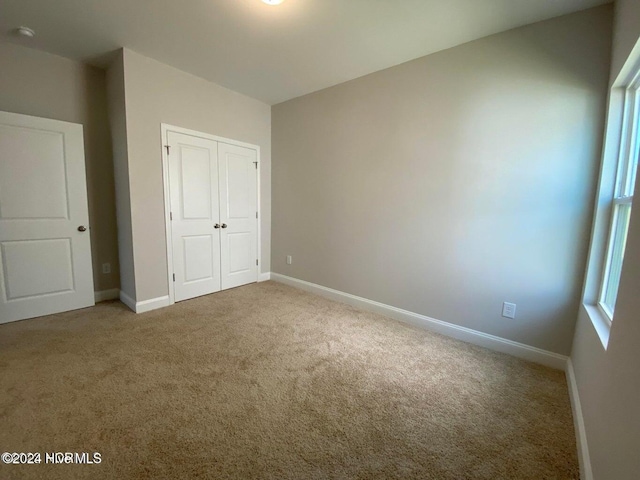 unfurnished bedroom with carpet floors and a closet