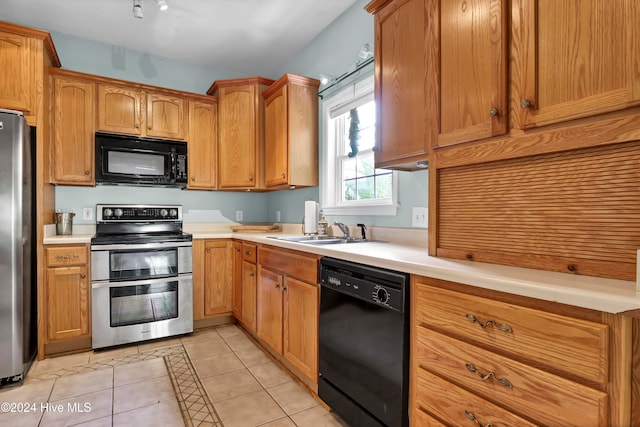 kitchen with sink, light tile patterned floors, and black appliances