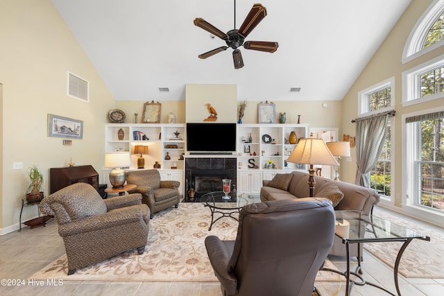 tiled living room featuring a fireplace, high vaulted ceiling, and ceiling fan