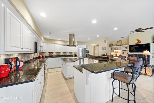 kitchen with a kitchen island, white cabinetry, island exhaust hood, and appliances with stainless steel finishes