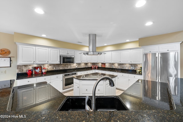 kitchen featuring island exhaust hood, backsplash, stainless steel appliances, sink, and white cabinets