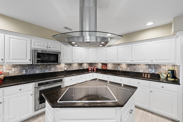 kitchen with white cabinets, a kitchen island, and appliances with stainless steel finishes