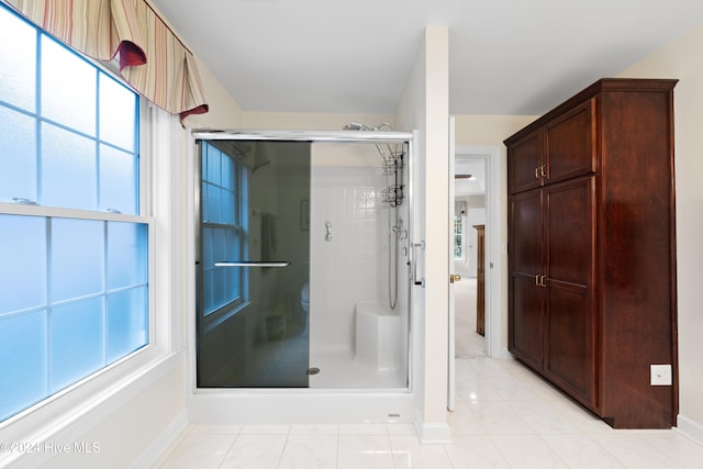 bathroom featuring tile patterned floors and a shower with shower door