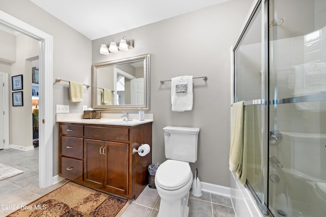 bathroom with tile patterned flooring, vanity, toilet, and a shower with door