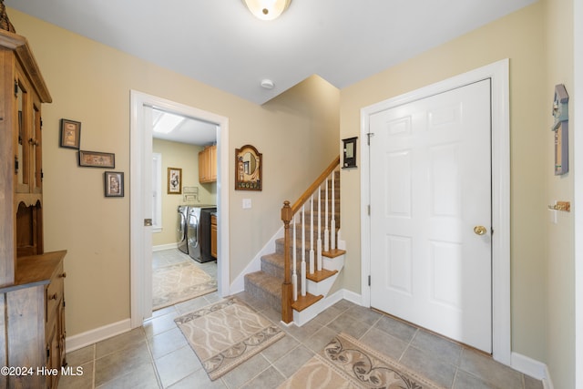 entryway with washer and dryer and light tile patterned flooring