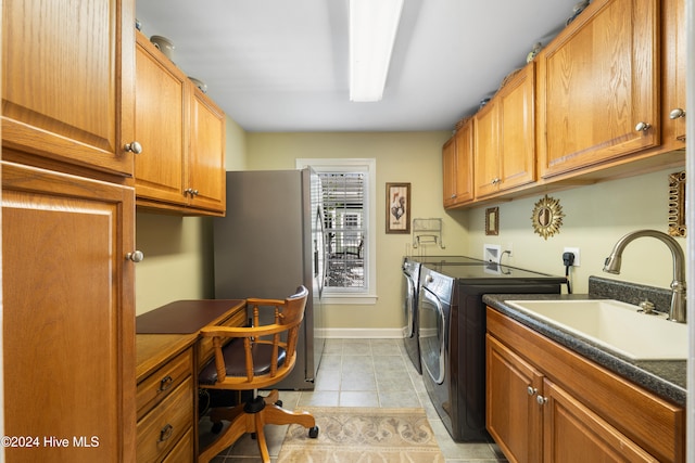 laundry room featuring cabinets, light tile patterned floors, washer and clothes dryer, and sink