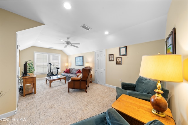 carpeted living room with ceiling fan and vaulted ceiling