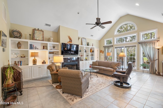 living room with ceiling fan, light tile patterned floors, high vaulted ceiling, and a premium fireplace