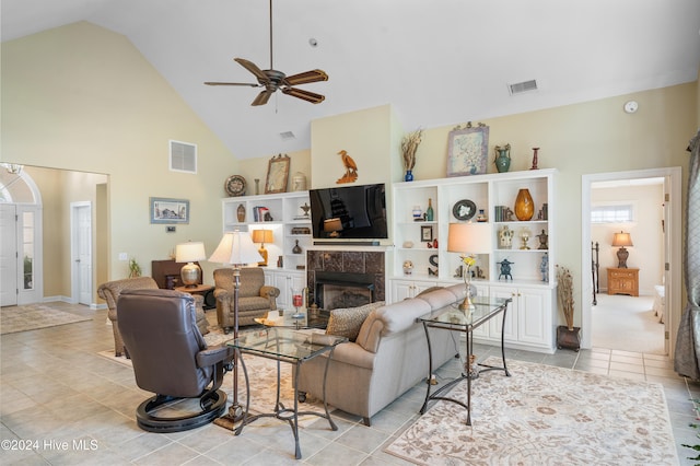 living room featuring ceiling fan, a fireplace, light tile patterned floors, and high vaulted ceiling