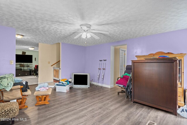 interior space with ceiling fan, hardwood / wood-style floors, and a textured ceiling