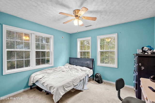 carpeted bedroom with a textured ceiling and ceiling fan