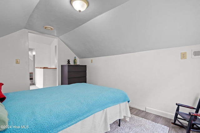 bedroom with lofted ceiling and hardwood / wood-style flooring