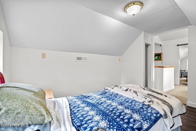 bedroom featuring wood-type flooring and vaulted ceiling