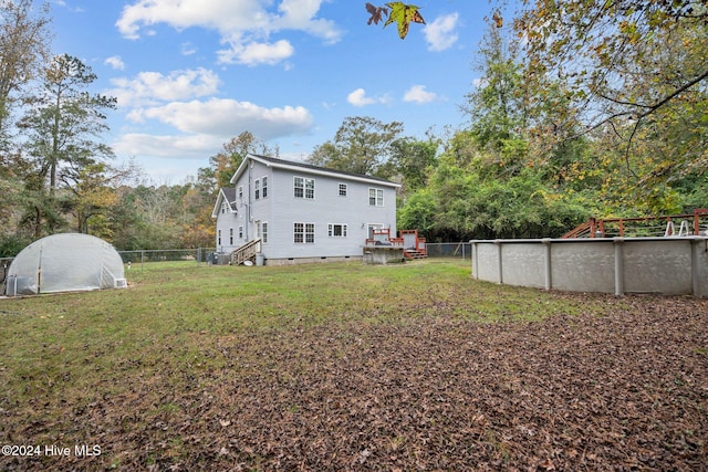 rear view of house featuring a yard