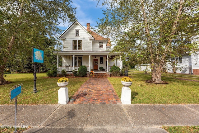 505 Broad St, Oriental, NC 28571 - view of front of house featuring a porch, a front yard, and a chimney