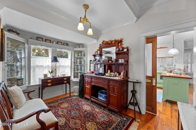 living area with light hardwood / wood-style floors and crown molding