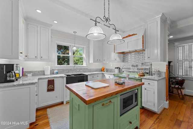 kitchen featuring light hardwood / wood-style floors, a center island, white cabinetry, and appliances with stainless steel finishes