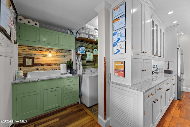 kitchen featuring white cabinets, green cabinets, ornamental molding, dark hardwood / wood-style flooring, and washer / dryer