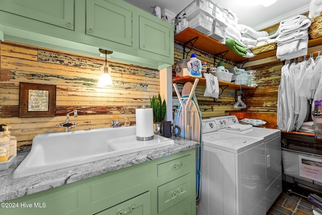 laundry room with separate washer and dryer, wooden walls, sink, and cabinets