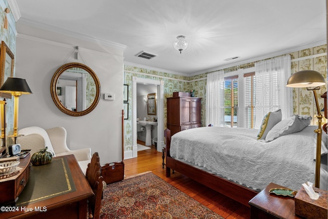 bedroom with ensuite bath, crown molding, and wood-type flooring