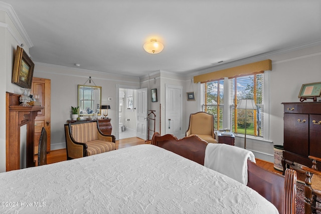 bedroom with ensuite bath, crown molding, and hardwood / wood-style flooring