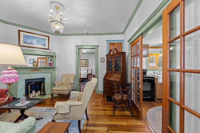 505 Broad St, Oriental, NC 28571 - living room with wood finished floors, a tiled fireplace, ornamental molding, a chandelier, and baseboards