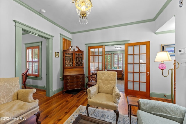 sitting room featuring dark hardwood / wood-style floors, an inviting chandelier, a wealth of natural light, and french doors