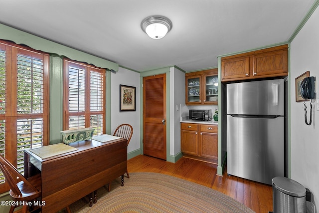505 Broad St, Oriental, NC 28571 - kitchen featuring freestanding refrigerator, brown cabinetry, black microwave, and light wood-type flooring