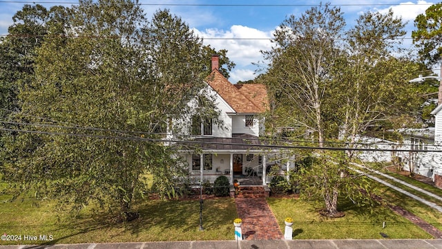 view of front of property featuring covered porch and a front lawn